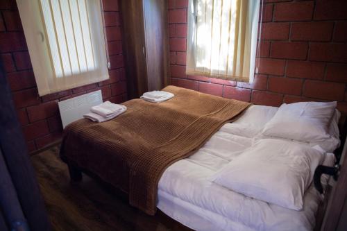 Una cama en una habitación de ladrillo con dos toallas. en Noravank L-and-L, en Aghavnadzor