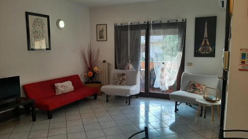 uma sala de estar com um sofá vermelho e duas cadeiras em PRESSI AEROPORTO COSTA SMERALDA em Olbia