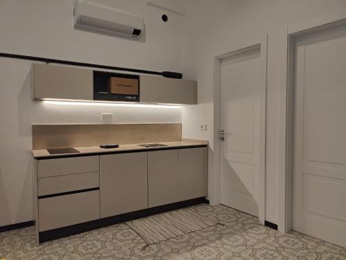eine Küche mit weißen Schränken und einer Mikrowelle in der Unterkunft Casa Aicardi in Alassio