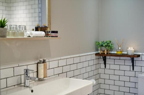 a white bathroom with a sink and a mirror at The Red Lion in Odiham