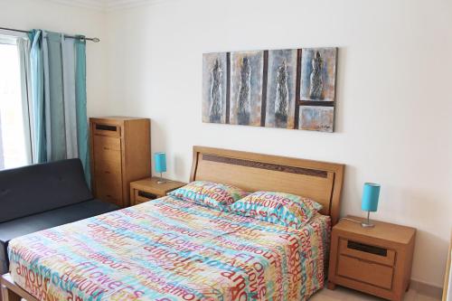 um quarto com uma cama e um quadro na parede em Varandas do Sol em Portimão