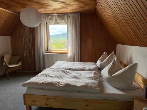Bett in einem Zimmer mit Fenster in der Unterkunft Ferienhaus Jurablick in Thalmässing