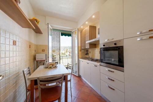 a kitchen with a table and chairs and a window at Victoria Apartment in Bordighera