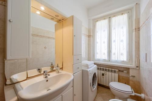 a white bathroom with a sink and a toilet at Victoria Apartment in Bordighera