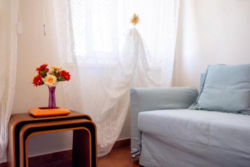 a vase of flowers on a table next to a couch at Victoria Apartment in Bordighera