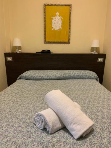 a bed with a white towel on top of it at Hotel Palace in Varazze