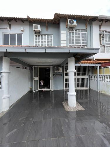 una casa con il pavimento bagnato dalla pioggia davanti di NAJIHAH HOMESTAY a Malacca