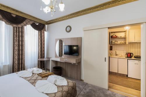 um quarto de hotel com uma cama e uma televisão em Punto Suite em Istambul