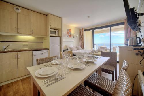 eine Küche mit einem Tisch mit Tellern und Weingläsern in der Unterkunft IMMOGROOM - 2BR - sea view - Swimming pool - Terrace - Parking - AC - Wifi in Cannes
