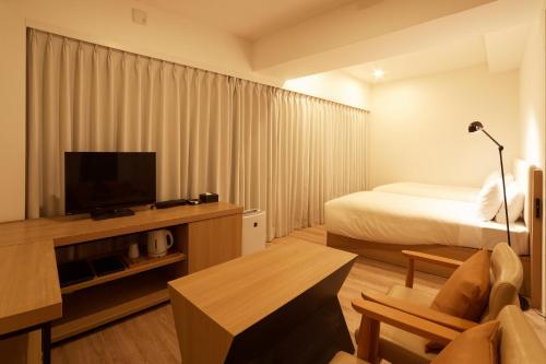 a hotel room with a bed and a flat screen tv at Sakura Terrace The Gallery in Kyoto