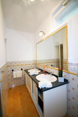 a bathroom with a sink and a large mirror at Cavalluccio Marino in Anacapri