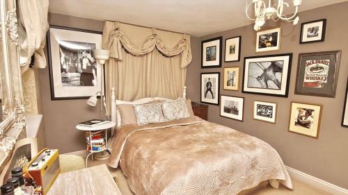 um quarto com uma cama e quadros nas paredes em Orchard Paddocks em Guildford