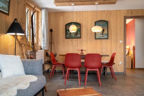 a dining room with red chairs and a table at Terre de Sapins in Orbey