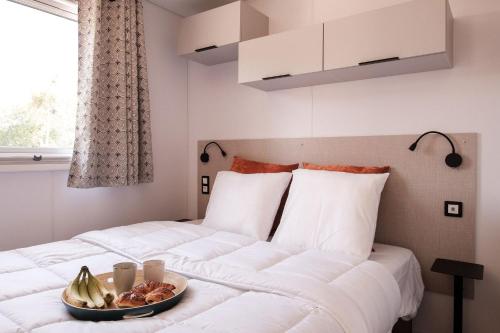 a bedroom with a bed with a bowl of fruit on it at L'Orée de l'Océan - Vendée in Landevieille
