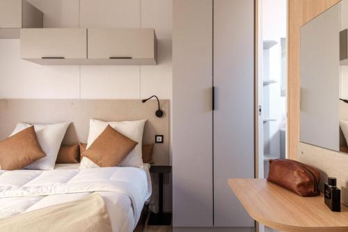 1 dormitorio con cama blanca y mesa en L'Orée de l'Océan - Vendée en Landevieille