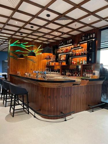 a bar in a restaurant with chairs and a counter at Studio One Hotel in Dubai