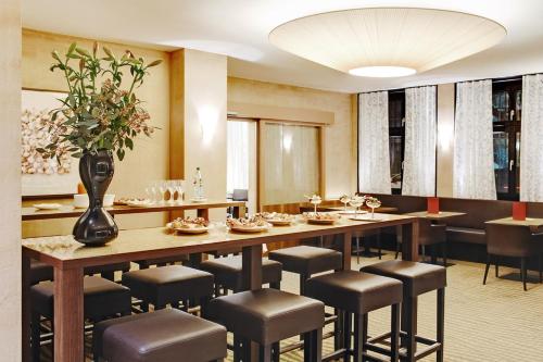 une salle à manger avec une grande table et des chaises dans l'établissement Hotel du Commerce, à Bâle