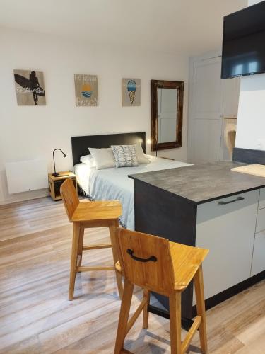 une chambre avec un lit, une table et des chaises dans l'établissement Le St Louis Chambre aménagée avec cuisine N°4, à La Rochelle