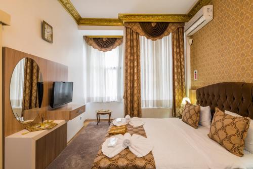 イスタンブールにあるPunto Suiteのベッドとテレビが備わるホテルルームです。