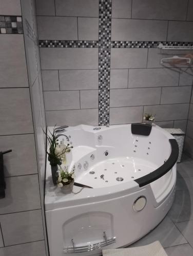 a white bath tub with a toilet in a bathroom at Chez Claude in Rimogne