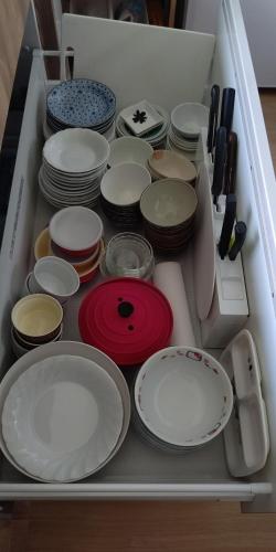 a drawer full of white plates and bowls and utensils at 海と湖が近い一軒家　”民泊あばしりの家” in Kitahama