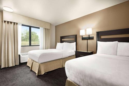 a hotel room with two beds and a window at Baymont by Wyndham Hearne in Hearne