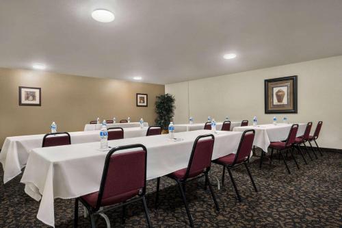 a conference room with long tables and chairs in it at Baymont by Wyndham Hearne in Hearne