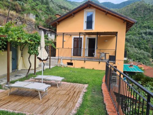 a house with a deck with a table and an umbrella at CA DE MIN Haut de Villa à Badalucco in Badalucco