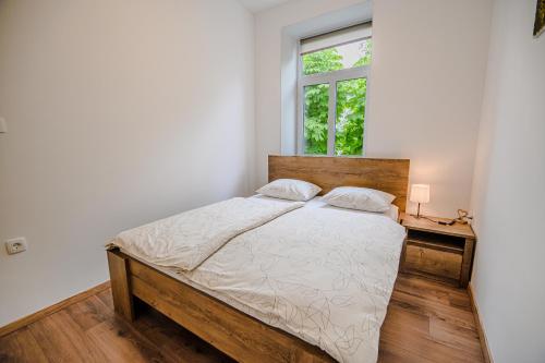 1 dormitorio con cama de madera y ventana en Guesthouse Pr'Šefu, en Brežice