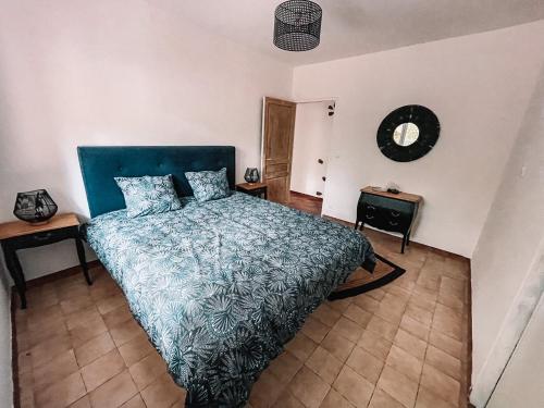 Schlafzimmer mit einem Bett mit blauer Tagesdecke in der Unterkunft Demeure du Dragon 5 chambres Piscine- 10 lits - personnes in Saint Jean du Pin