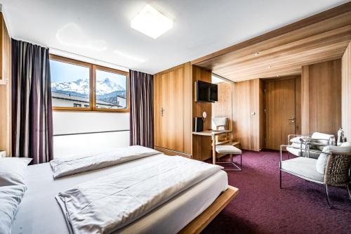 a hotel room with a bed and a desk at Hotel Alpina Sölden - Adults Only in Sölden