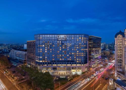 duży szklany budynek w mieście w nocy w obiekcie Regent Beijing w Pekinie