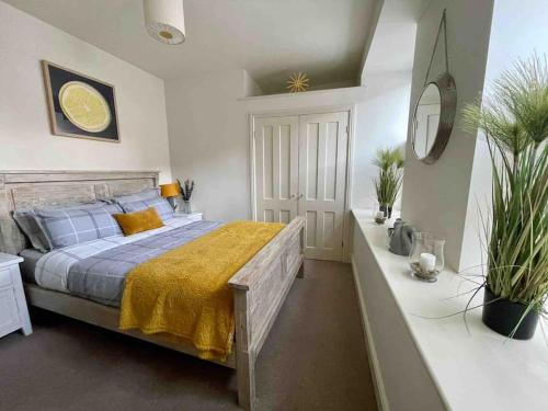 Luxurious 2 bedroom apartment in central Berwick في بيرويك أبون تويد: غرفة نوم عليها سرير مع بطانية صفراء