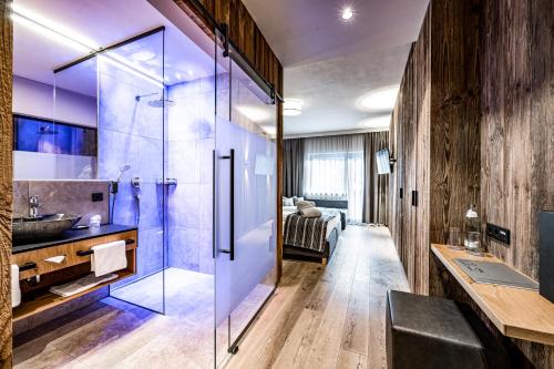 ein Bad mit einer Glasdusche und einem Waschbecken in der Unterkunft Hotel Alpina Sölden - Adults Only in Sölden