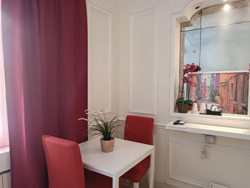 a dining room with a table and two red chairs at Navona Private Rooms bnb in Rome
