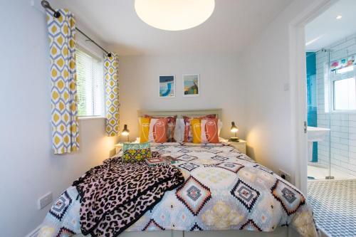 um quarto com uma cama grande e almofadas coloridas em Bosinver Farm Cottages Well Close em St Austell