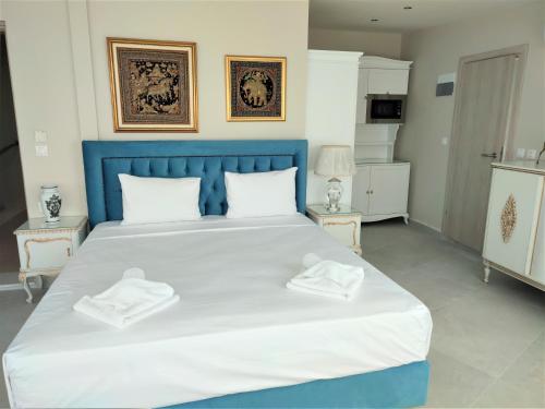 a bedroom with a large bed with two towels on it at Light Blue Hotel in Nea Kalikratia