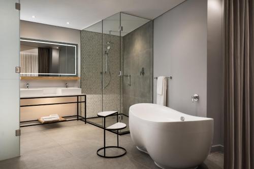 y baño con bañera, lavamanos y ducha. en Cape Town Marriott Hotel Crystal Towers en Ciudad del Cabo