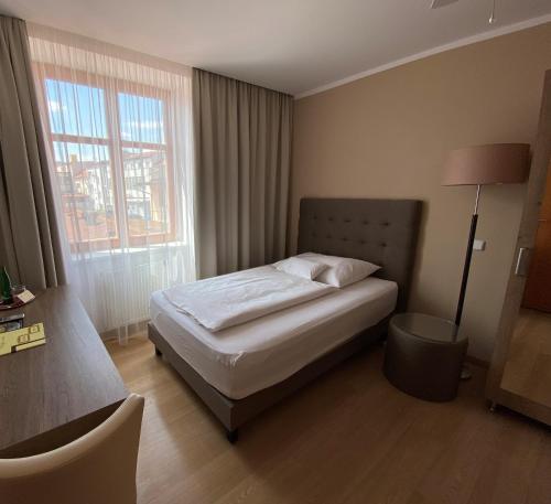 a bedroom with a bed and a large window at Hotel MAGISTR Vsetín in Vsetín