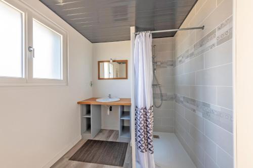 La salle de bains est pourvue d'une douche et d'un lavabo. dans l'établissement À la maison de Goulannou, à Tréflez