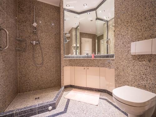 een badkamer met een toilet, een douche en een spiegel bij Dünenpark Binz - Komfortplus Ferienwohnung mit 1 Schlafzimmer und Terrasse im Erdgeschoss 049 in Binz