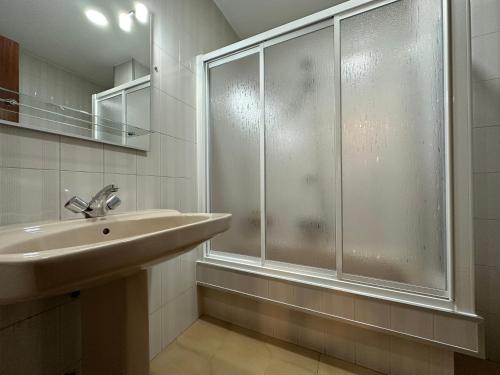 a bathroom with a sink and a glass shower at Oktheway Et Suseia in Sarria