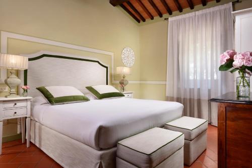 a bedroom with a large white bed and a window at Borgo Antico Casalbosco Holiday Home & Winery in Santomato 