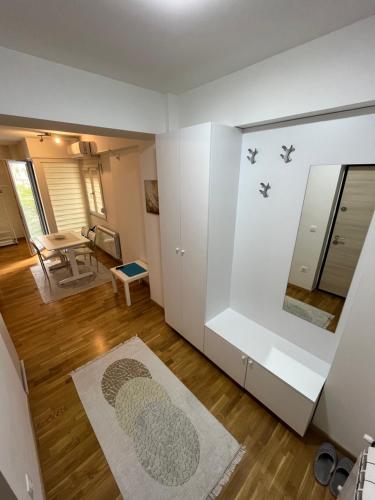uma sala de estar com paredes brancas e um espelho em Modern Rajcikk Apartment nearby downtown & Vardar river em Skopje