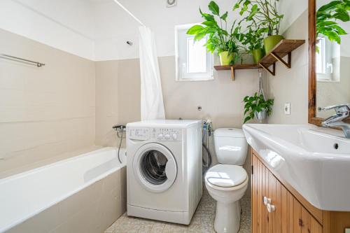 ein Badezimmer mit einer Waschmaschine und einem Waschbecken in der Unterkunft BeGuest Casa Romãzeira Typical Vila in Alfarrobeira