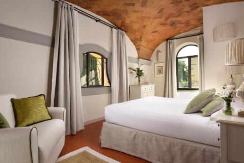 a bedroom with a large white bed and a couch at Borgo Antico Casalbosco Holiday Home & Winery in Santomato 