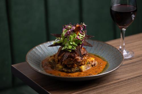 a plate of food on a table with a glass of wine at Holiday Inn London Gatwick - Worth by IHG in Crawley