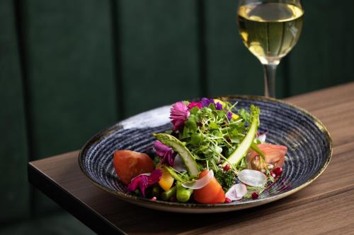 a plate of food on a table with a glass of wine at Holiday Inn London Gatwick - Worth by IHG in Crawley