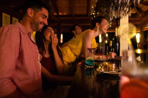 a group of people sitting at a table in a bar at JA Enchanted Island Resort Seychelles in Round Island