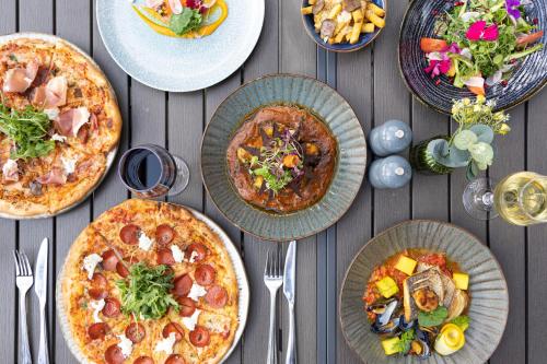 a group of pizzas on plates on a table at Holiday Inn London Gatwick - Worth by IHG in Crawley